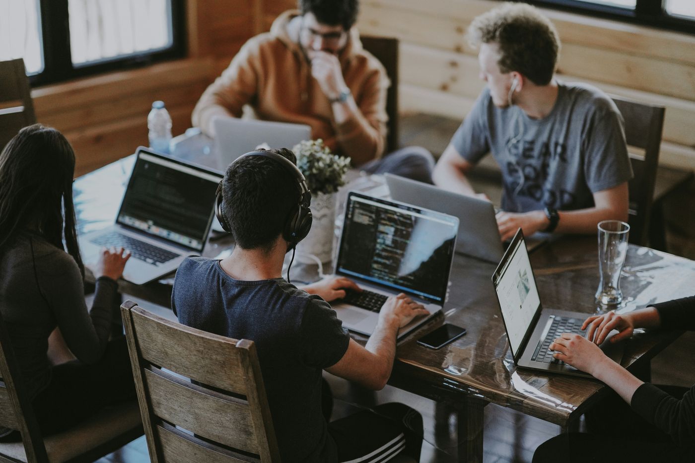 Coworkers collaborating around a table with laptops, representing business insurance coverage
